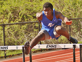 Young man jumping hurdles